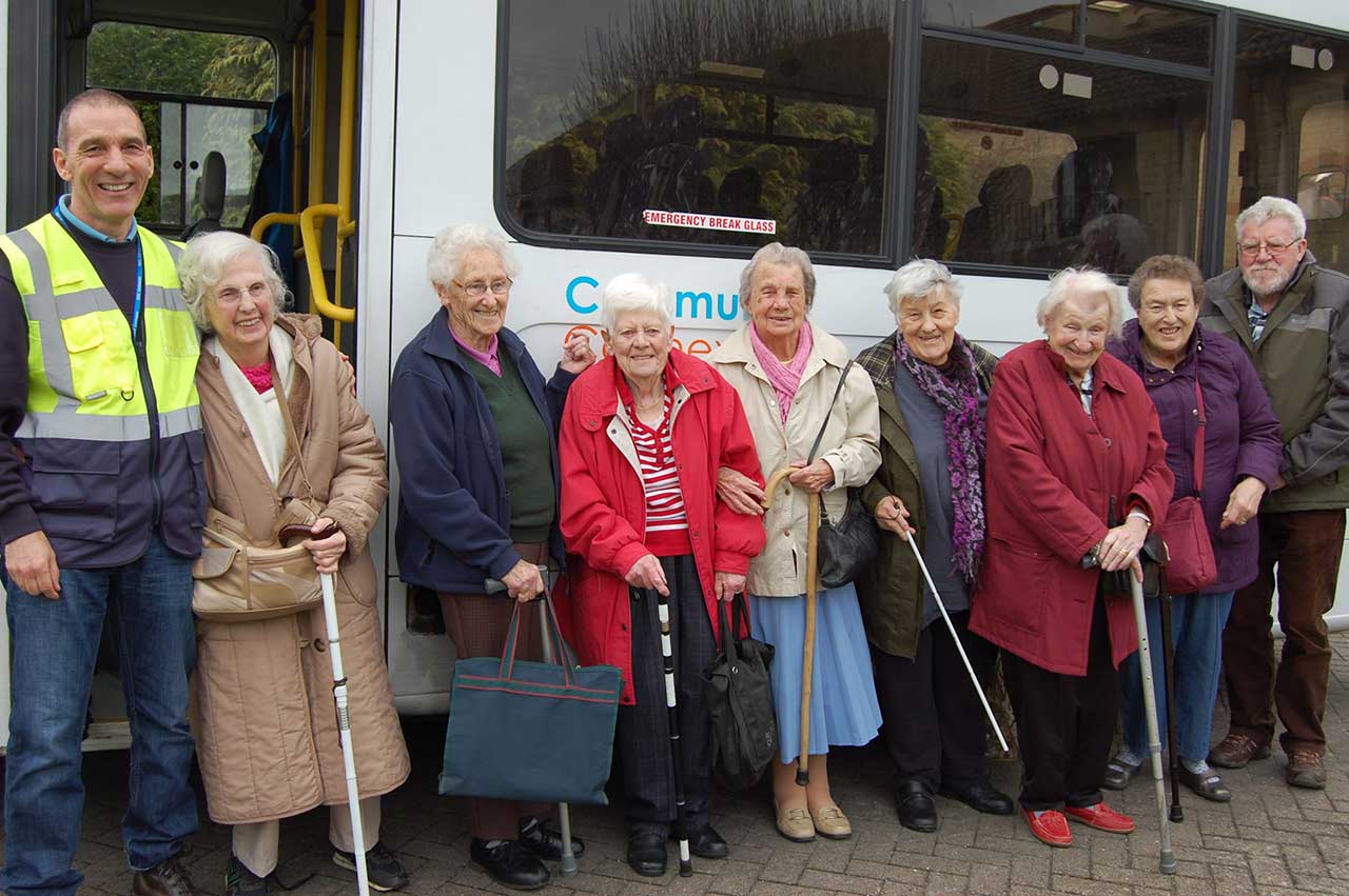 Bus driver with happy travellers